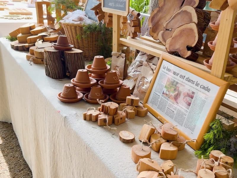 Wooden crafts and terracotta pots on a linen-covered market stall